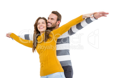 Young couple standing with arms outstretched