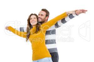 Young couple standing with arms outstretched