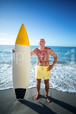 Senior man posing with a surfboard