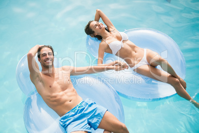 Couple smiling while relaxing on inflatable ring