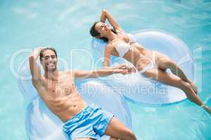 Couple smiling while relaxing on inflatable ring