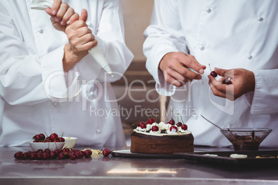 Chefs decorating a cake they just made
