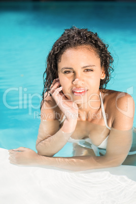 Portrait of beautiful woman leaning on poolside