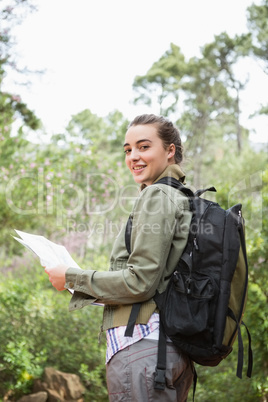 Smiling woman with backpack and map