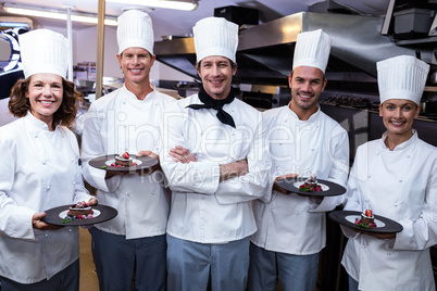 Happy chefs presenting their dessert plates