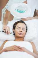 Woman with eyes closed while receiving facial massage