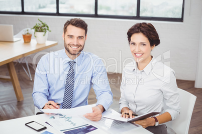 Happy business people with documents sitting in office Happy business people with documents sitting in office