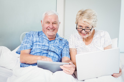 Portrait of happy couple with technologies