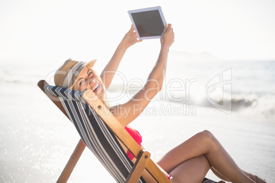 Happy woman talking a selfie on a digital tablet