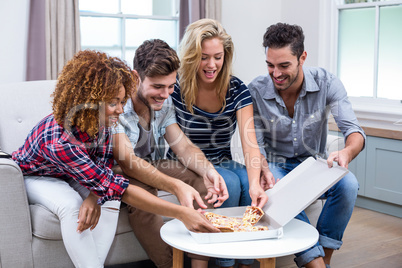 Multi-ethnic friends enjoying pizza at home