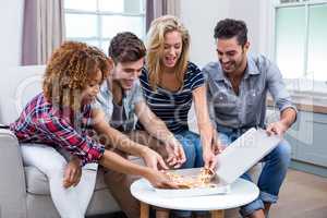 Multi-ethnic friends enjoying pizza at home