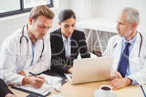 Medical team using laptop in conference room