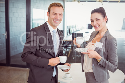 Businessman and businesswoman having tea during breaktime