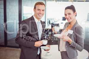 Businessman and businesswoman having tea during breaktime