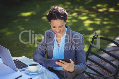 Businesswoman using tablet with coffee