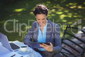 Businesswoman using tablet with coffee