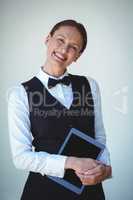 Smiling waitress holding a tablet