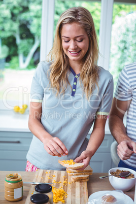 Happy woman preparing sandwich