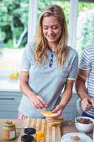 Happy woman preparing sandwich