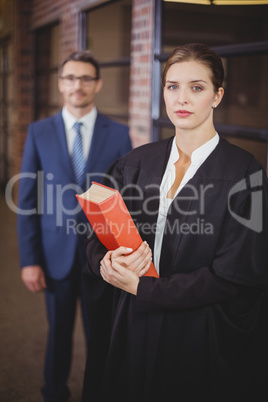 Female lawyer with businessman standing in background