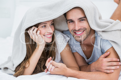 Happy couple enjoying under blanket