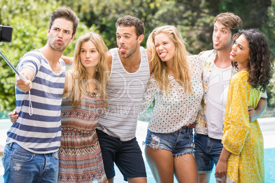 Group of friends taking a selfie near pool