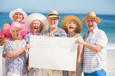 Senior friends holding blank paper