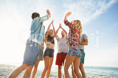 Friends doing high five on the beach