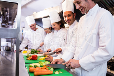 Team of chefs chopping vegetables