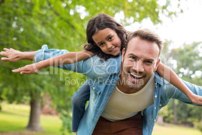 Father giving piggyback ride to daughter