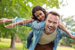 Father giving piggyback ride to daughter