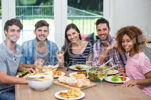 Happy multi-ethnic friends having meal at table