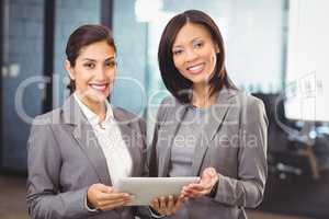 Happy businesswomen with digital tablet