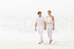 Happy young couple walking on the beach