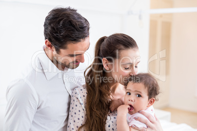 Mother kissing baby with father