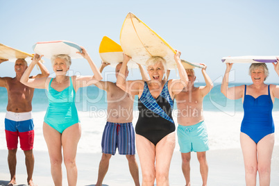 Seniors holding surfboards at the beach