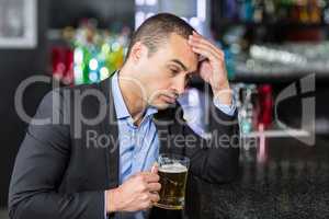 Worried businessman drinking a beer