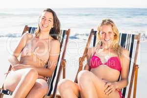 Portrait of two women relaxing on armchair on the beach