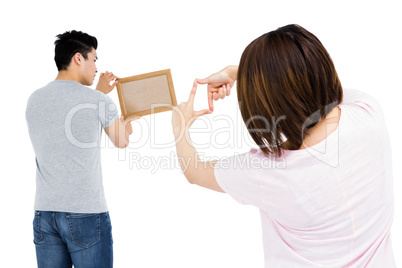 Young couple putting up picture frame