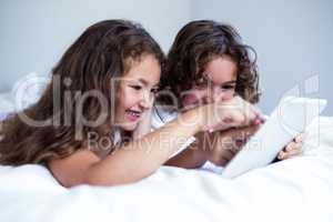Brother and sister using digital tablet