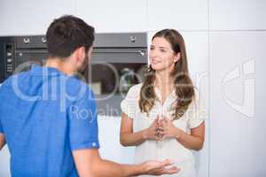 Man explaining wife in kitchen