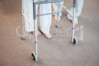Low section of elderly man and woman with walker