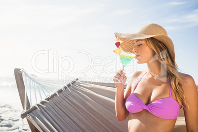 Woman drinking cocktail in hammock