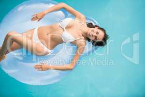 Beautiful young woman relaxing on inflatable ring