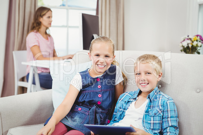 Children with digital tablet while mother in background