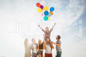 Portrait of friends holding balloon