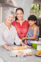 Portrait of grandmother with family making bread