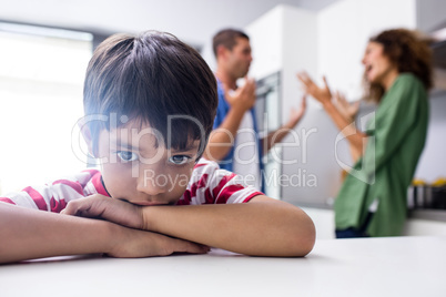 Boy feeling sad while his parents quarrelling