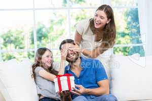 Man surprised with gift in sofa