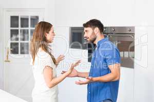 Couple arguing while standing in kitchen